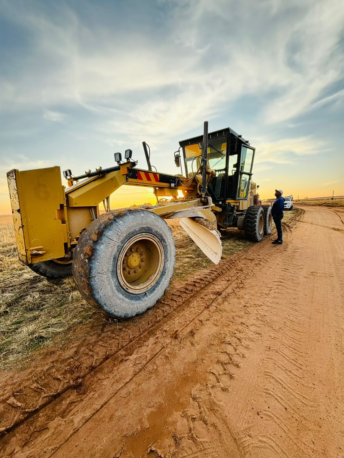 Grapeseed Trading motor grader working a haul road at sunset