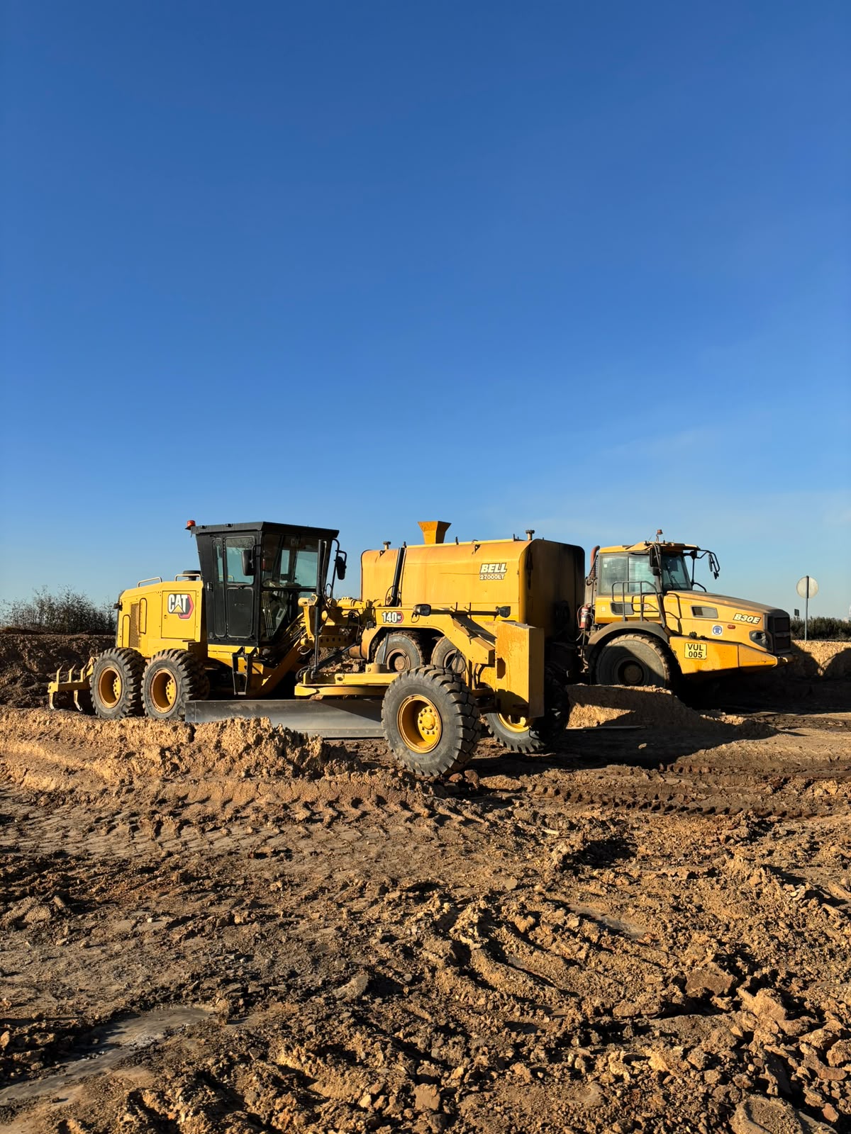 Grader, water bowser and Bell ADT on a site