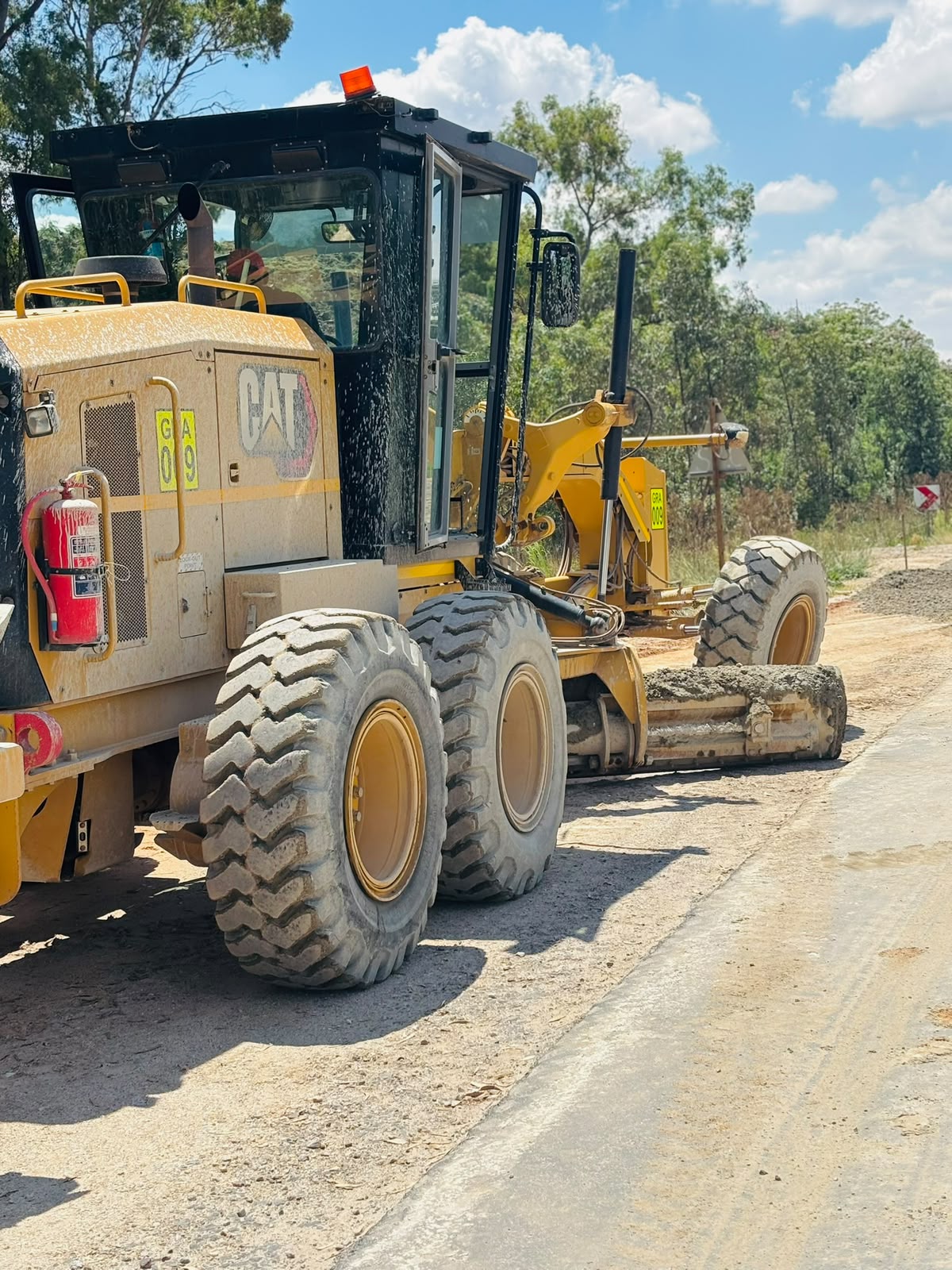 CAT 140 Motor Grader grading a road