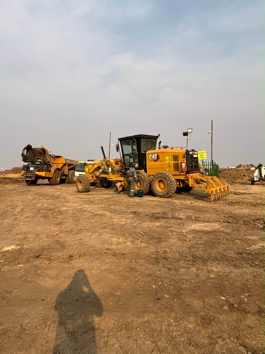 Grader and articulated dump truck at the diesel bay